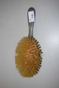 A silver backed dressing table brush