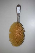 A silver backed dressing table brush