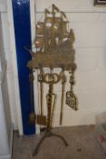 A large brass fire companion set with galleon decoration