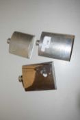 A group of three stainless steel/pewter hip flasks