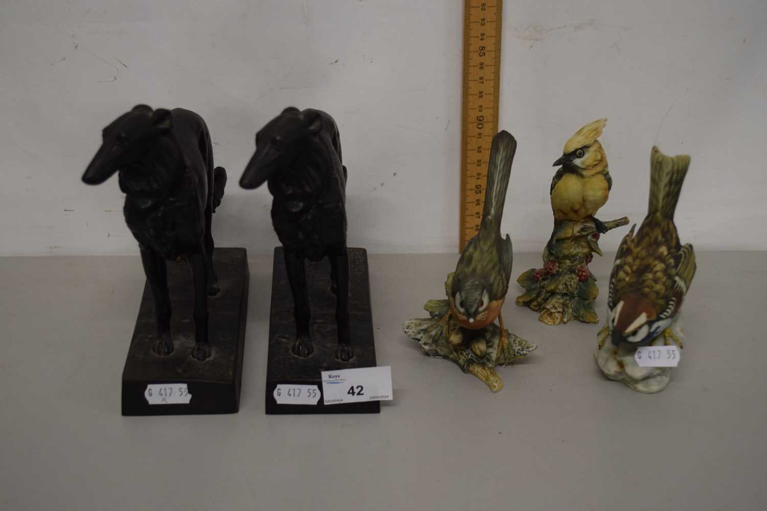 A pair of Russian bronzed metal models of dogs dated 1978 together with a group of three porcelain