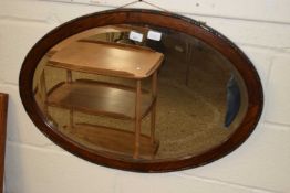 An early 20th Century oak framed oval bevelled wall mirror