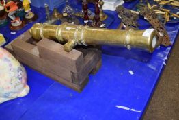 A replica brass cannon, approx 23" long, display piece only, non-firing, set on a hardwood stand