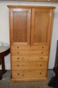 A narrow early 20th Century pine cabinet with two panelled doors over five graduated drawers, 84cm