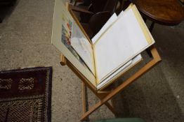 A folio stand containing a range of various framed and unframed prints, watercolours etc