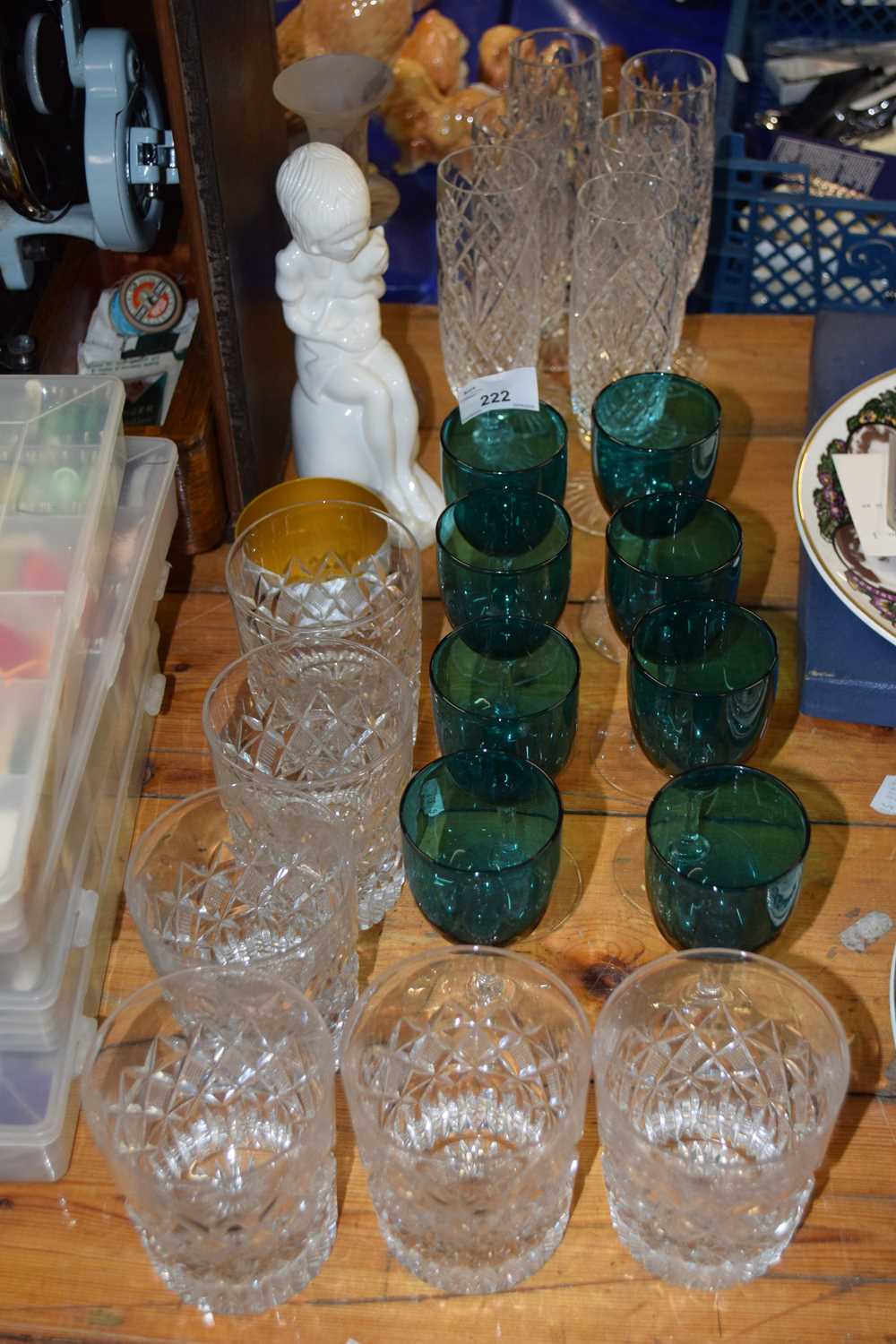 A group of various drinking glasses to include turquoise wine glasses, clear glass tumblers and