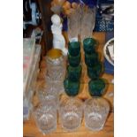 A group of various drinking glasses to include turquoise wine glasses, clear glass tumblers and