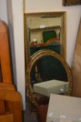 An oval bevelled wall mirror and a rectangular bevelled wall mirror both in gilt finish frames