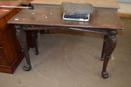 A late 19th Century oak side table with lion mask decoration and ball and claw feet