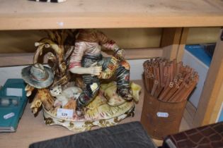 A large Capodimonte figure of an accordion player together with a box of pencils