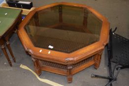An octagonal glass top coffee table