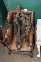 A child's leather upholstered wing back chair, for restoration together with a horse harness