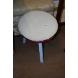 A small milking stool with blue painted legs