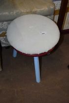 A small milking stool with blue painted legs