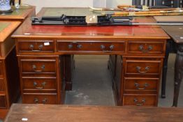 A yew wood veneered twin pedestal office desk with a red leather inset, 120cm wide