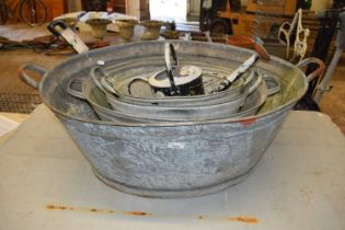 Four galvanised tubs together with a galvanised watering can