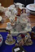 A Staffordshire flat back group of a Highlander and lady with a clock face together with a pair of