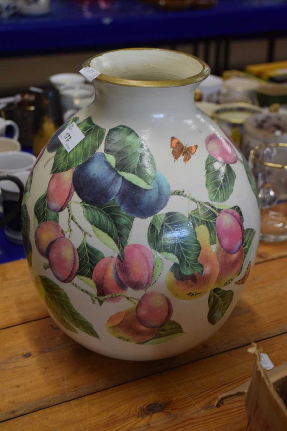 A large pottery vase of baluster shape decorated with fruit and butterflies