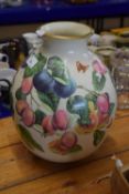 A large pottery vase of baluster shape decorated with fruit and butterflies