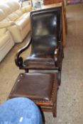 A leather upholstered chair and footstool combo