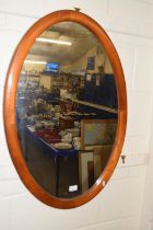 An oval hall mirror in wooden frame
