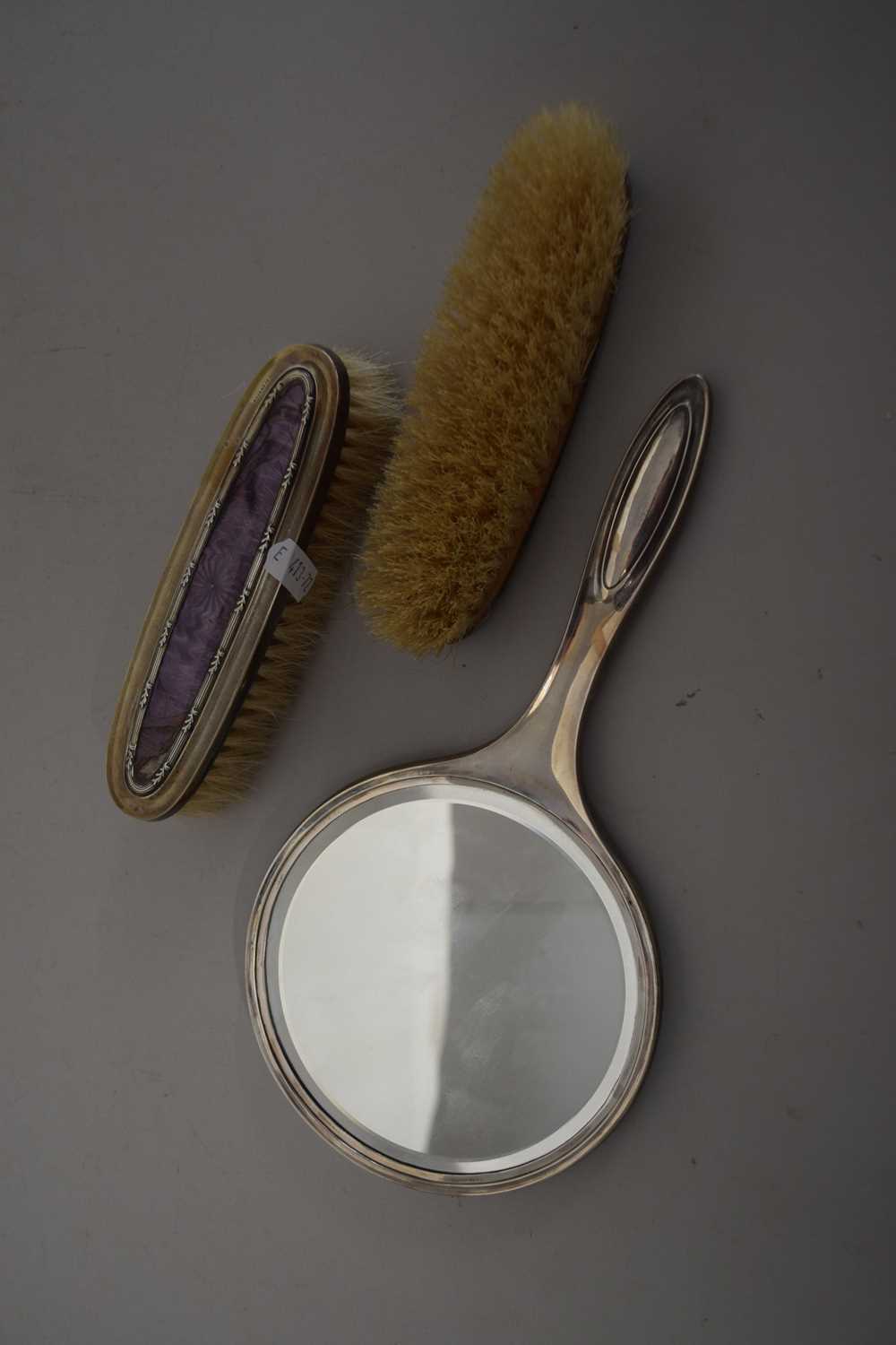 An Art Deco dressing table mirror and two silver brushes