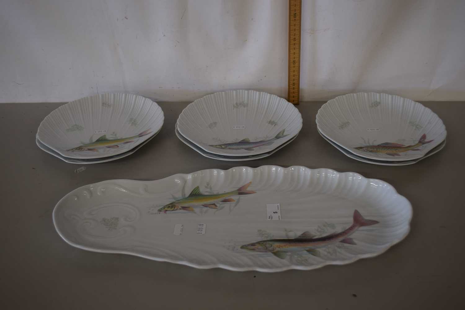 A continental porcelain fish set with large dish and six smaller oyster shaped dishes decorated with