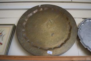 A large circular copper tray with geometric design