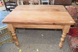 A distressed pine kitchen table with heavily turned legs, approx 122 x 90cm