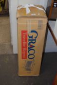 A boxed Graco travel cot