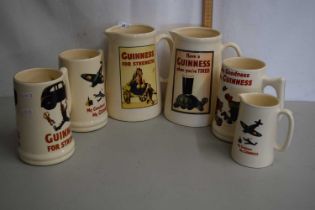 A group of six reproduction Guinness jugs and tankards