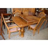 A reproduction oak veneered extending dining table and six chairs