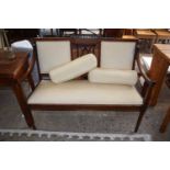 An Edwardian mahogany framed sofa with cream upholstery and bolster cushions