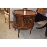 Reproduction hardwood drinks cabinet of oval form with lift off tray top