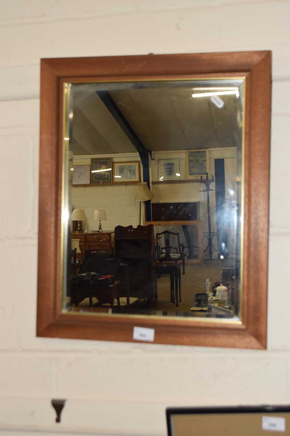 A modern bevelled wall mirror in hardwood frame