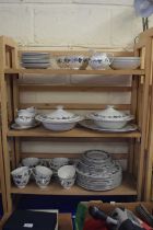 A large quantity of Royal Doulton burgundy dinner and tea wares (three shelves)