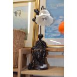 A bronzed figural lamp with frosted glass shade