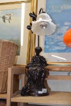 A bronzed figural lamp with frosted glass shade