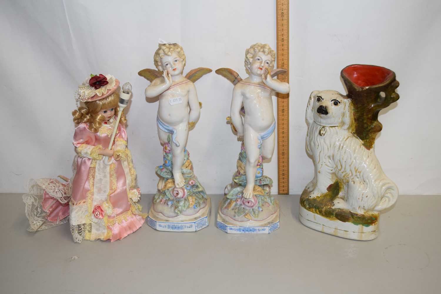 A pair of continental porcelain models of cherubs (a/f) together with a further Staffordshire