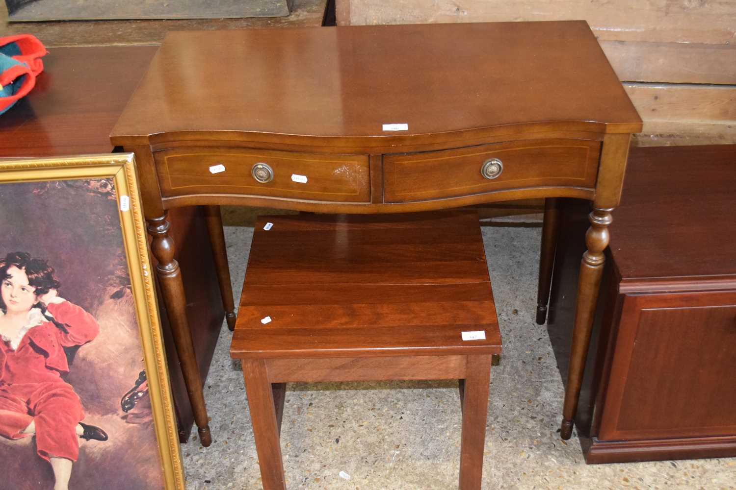 A reproduction mahogany veneered serpentine front to drawer side table