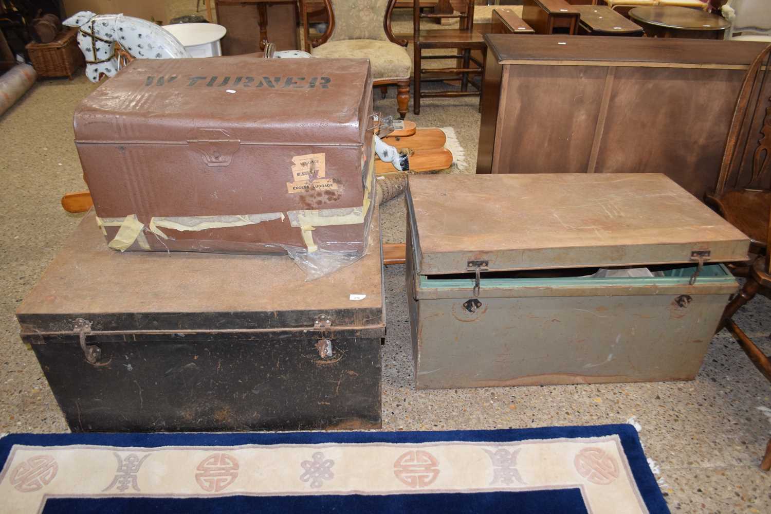 A group of three vintage metal trunks