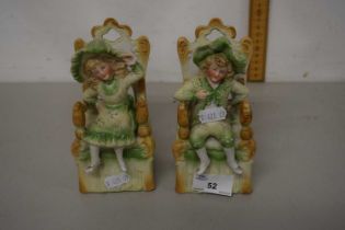 A pair of continental bisque figures in oversized chairs