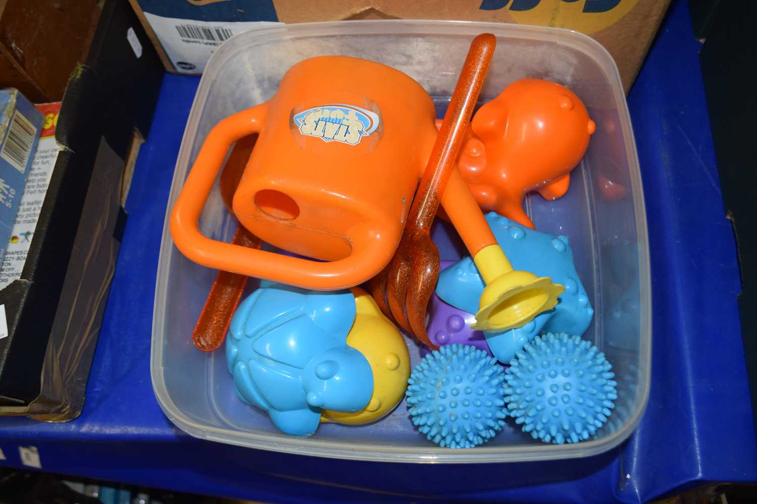 Plastic box containing a quantity of children's plastic toys