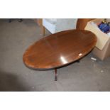 A modern mahogany veneered oval coffee table