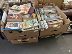 Four boxes containing a large quantity of various paperback and other books