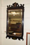 An ebonised framed wall mirror in the Georgian style with swan mount