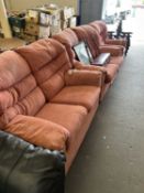 A pink upholstered four piece suite