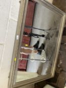 A bevelled wall mirror in silver finish frame