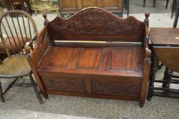 A 20th Century mahogany hall bench with storage base and carved decoration