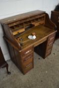 An early 20th Century oak roll top desk